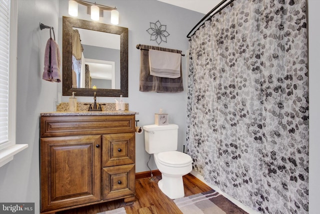 bathroom with toilet, vanity, a shower with curtain, and wood finished floors