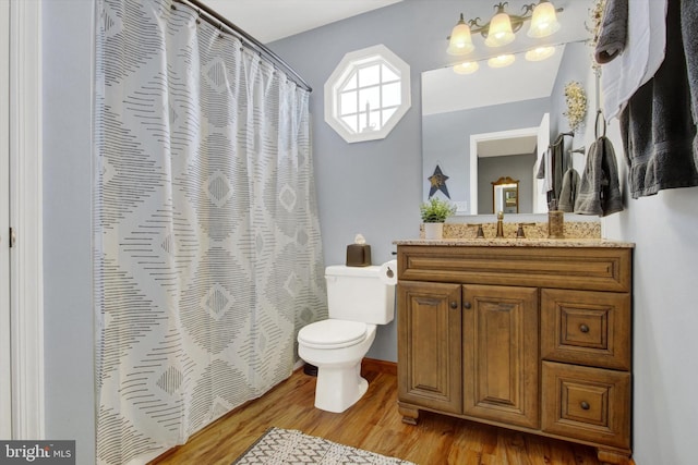 bathroom featuring a shower with curtain, toilet, wood finished floors, and vanity