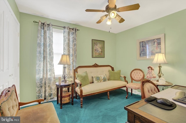 sitting room with a ceiling fan and carpet floors