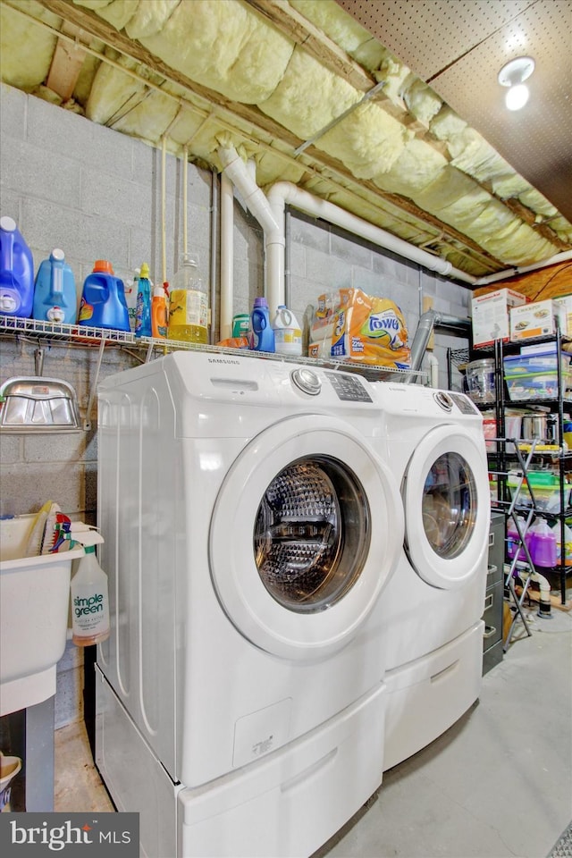 washroom with washer and dryer, concrete block wall, and laundry area