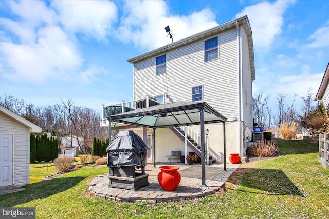 back of property with a yard, stairway, a deck, and a patio area