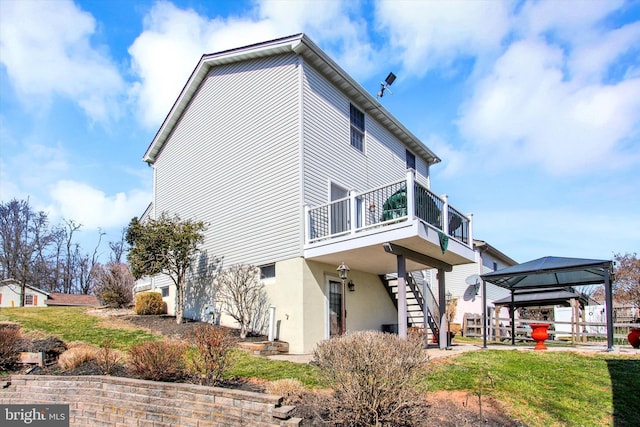 view of side of property with a gazebo, stucco siding, and stairs