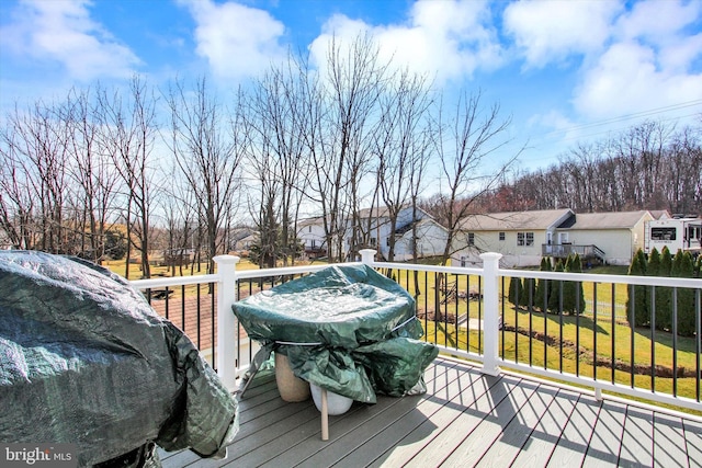 wooden deck with a residential view and a lawn