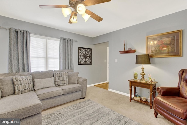 living room with carpet flooring, ceiling fan, and baseboards