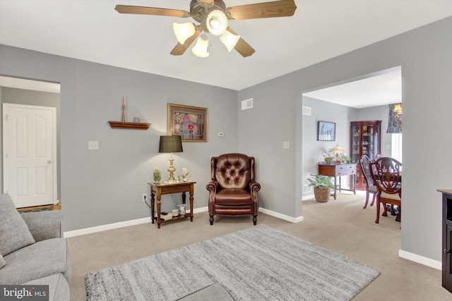 sitting room with a ceiling fan, visible vents, carpet, and baseboards