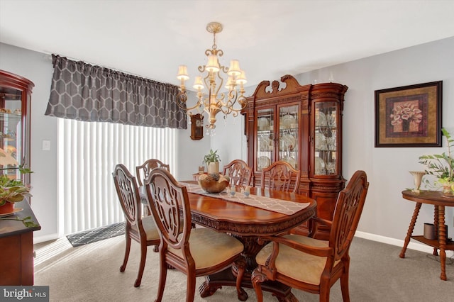 dining room with baseboards, carpet, and a chandelier