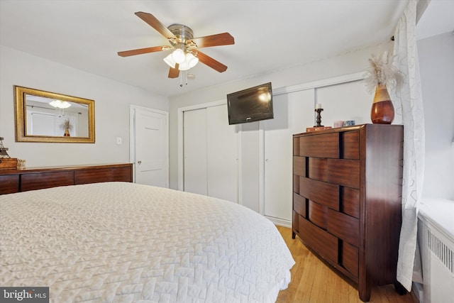 bedroom with ceiling fan, a closet, light wood-style flooring, and radiator heating unit