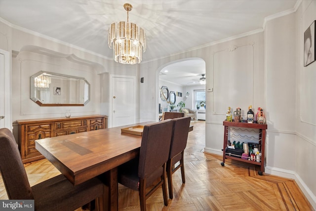 dining space with ceiling fan with notable chandelier, arched walkways, and ornamental molding