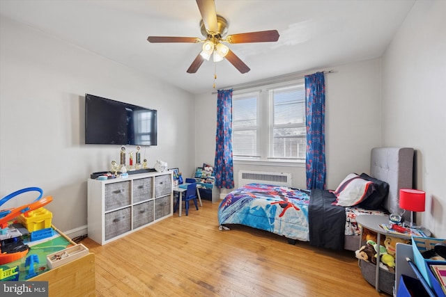 bedroom featuring radiator, ceiling fan, and hardwood / wood-style flooring