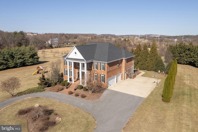 greek revival house with concrete driveway, an attached garage, a front lawn, and a shingled roof