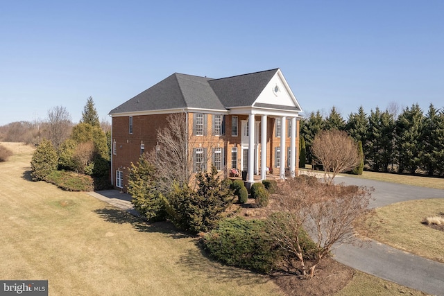 view of property exterior with a yard and brick siding