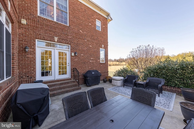 view of patio with area for grilling, outdoor dining space, and entry steps