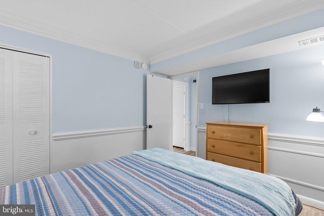 bedroom featuring a closet, visible vents, and ornamental molding