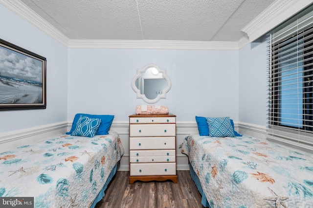 bedroom with a textured ceiling, wood finished floors, and ornamental molding