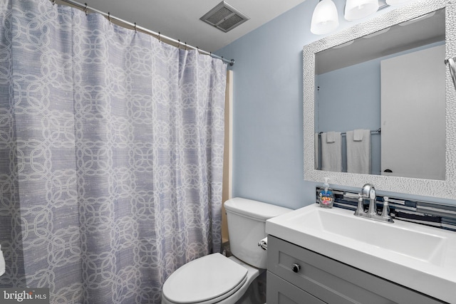 bathroom featuring visible vents, toilet, and vanity