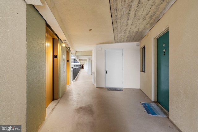 corridor with a textured wall and concrete floors