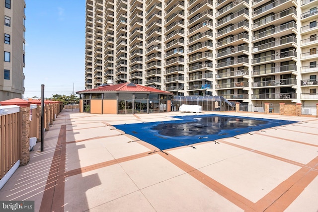 community pool featuring a gazebo, a patio area, and fence
