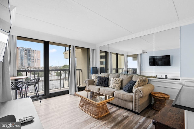 living room featuring a view of city, wood finished floors, and ornamental molding