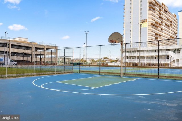 view of basketball court with community basketball court and fence