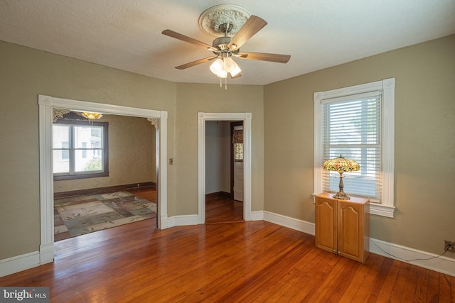 empty room with baseboards, light wood finished floors, and ceiling fan