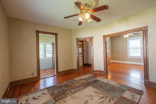 unfurnished bedroom featuring baseboards, multiple windows, and hardwood / wood-style flooring