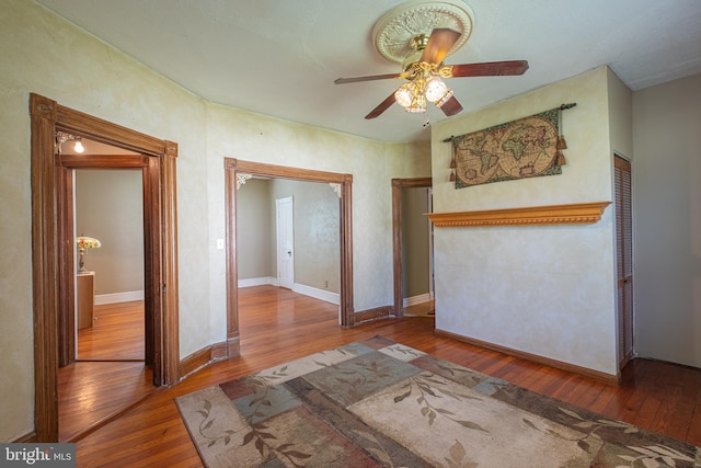 unfurnished room with baseboards, ceiling fan, and hardwood / wood-style flooring