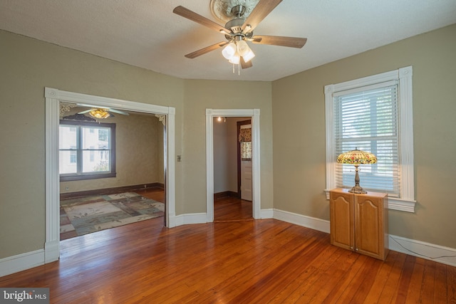 spare room with ceiling fan, baseboards, and light wood-style flooring