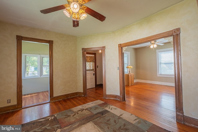 unfurnished bedroom with ceiling fan, baseboards, and wood-type flooring