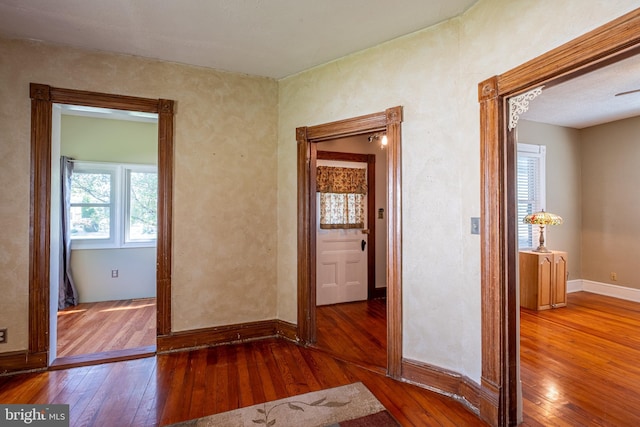 hall with baseboards and hardwood / wood-style floors