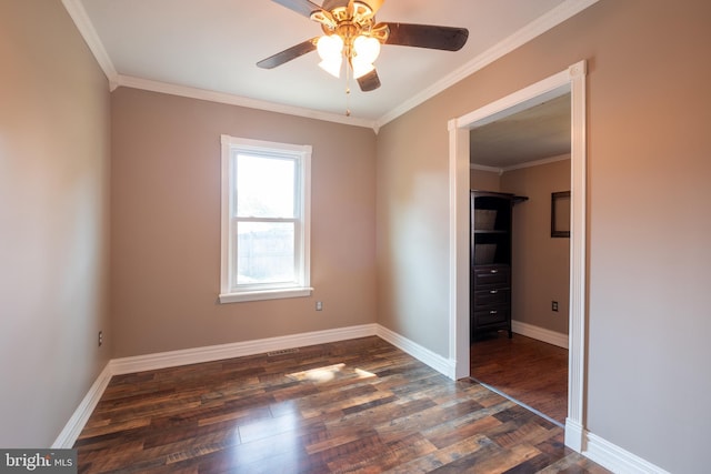 unfurnished bedroom featuring crown molding, dark wood-style floors, baseboards, and ceiling fan