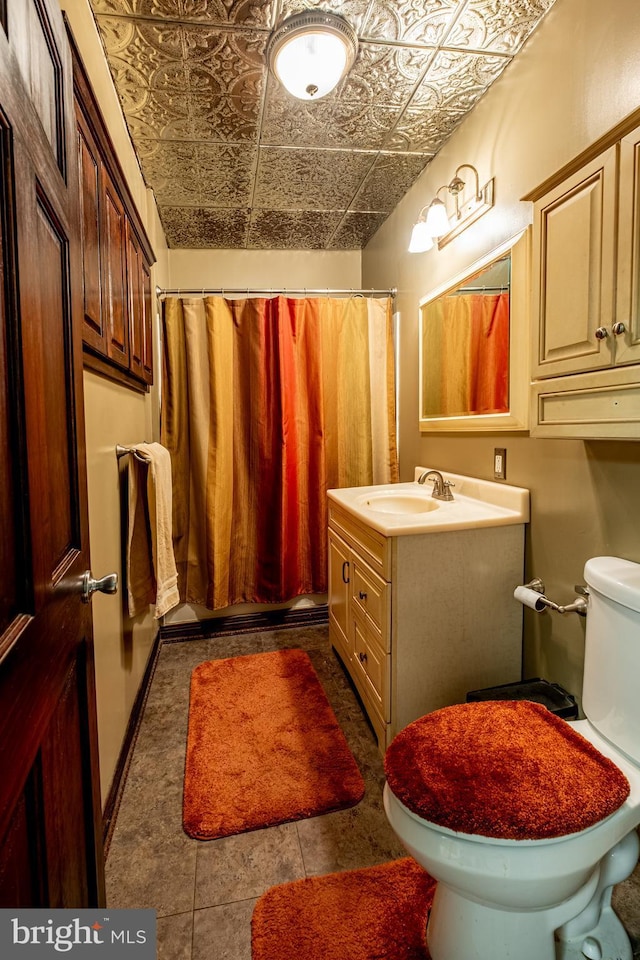 bathroom with toilet, an ornate ceiling, a shower with shower curtain, baseboards, and vanity