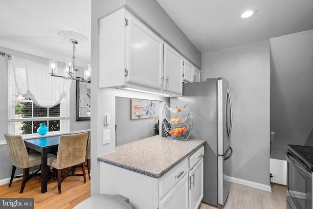 kitchen with white cabinetry, a notable chandelier, light wood-style floors, and electric range oven