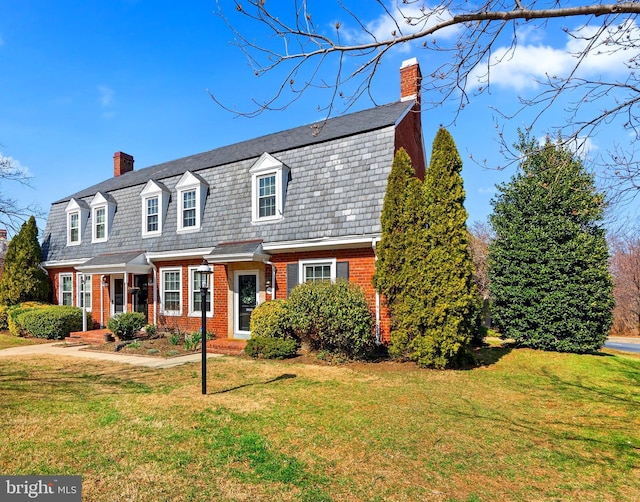 colonial inspired home featuring a front yard, brick siding, and a chimney