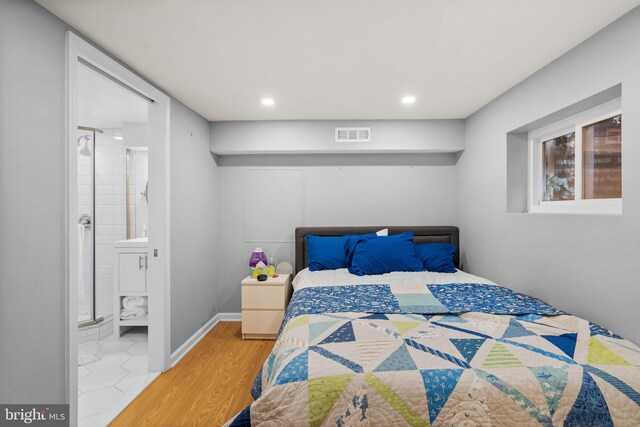 bedroom featuring wood finished floors, visible vents, baseboards, recessed lighting, and connected bathroom