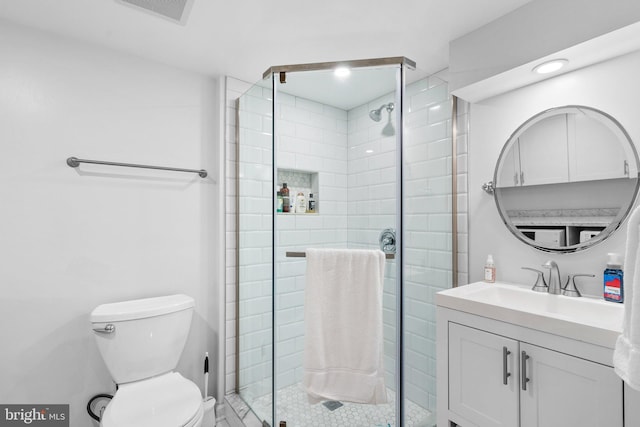 bathroom with a stall shower, toilet, and vanity