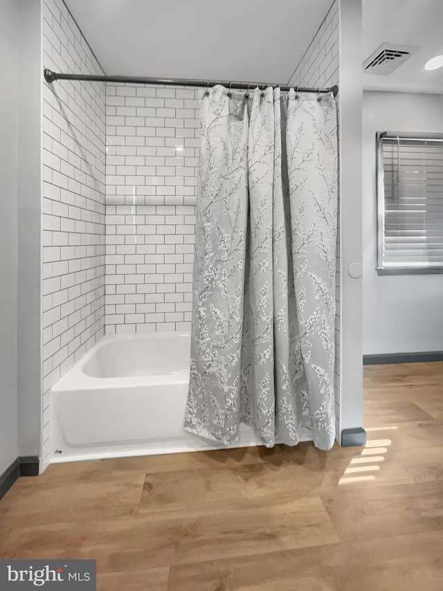 full bath featuring visible vents, shower / bath combo with shower curtain, and wood finished floors