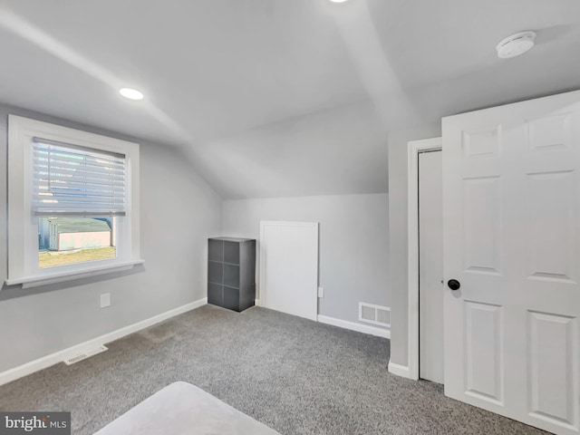 additional living space featuring visible vents, baseboards, lofted ceiling, and carpet floors