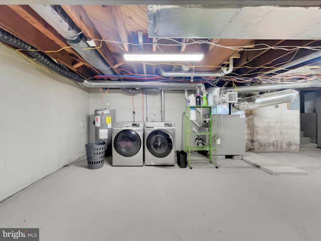 unfinished basement featuring electric water heater and separate washer and dryer