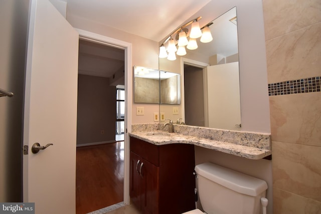 bathroom featuring vanity, toilet, and wood finished floors