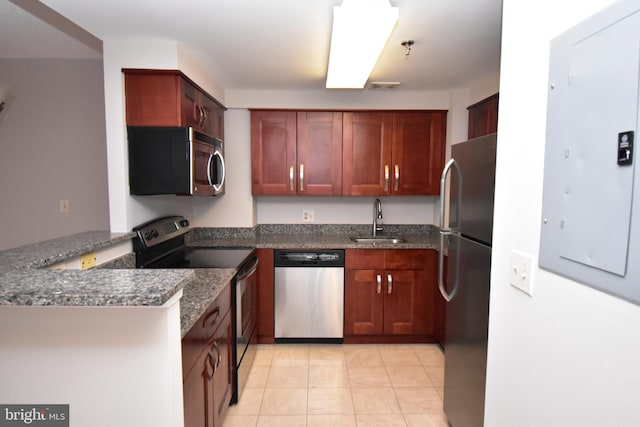 kitchen featuring visible vents, a peninsula, light tile patterned flooring, a sink, and appliances with stainless steel finishes