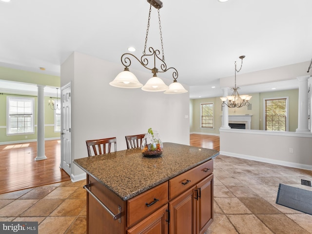 kitchen with a wealth of natural light, a center island, and ornate columns