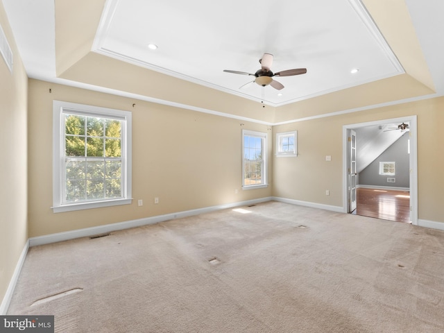 unfurnished room featuring visible vents, baseboards, carpet, a tray ceiling, and a ceiling fan