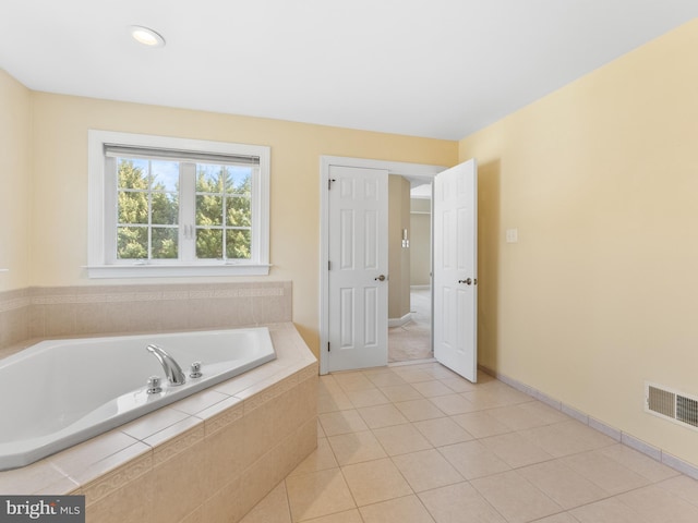 full bathroom with tile patterned flooring, a garden tub, baseboards, and visible vents