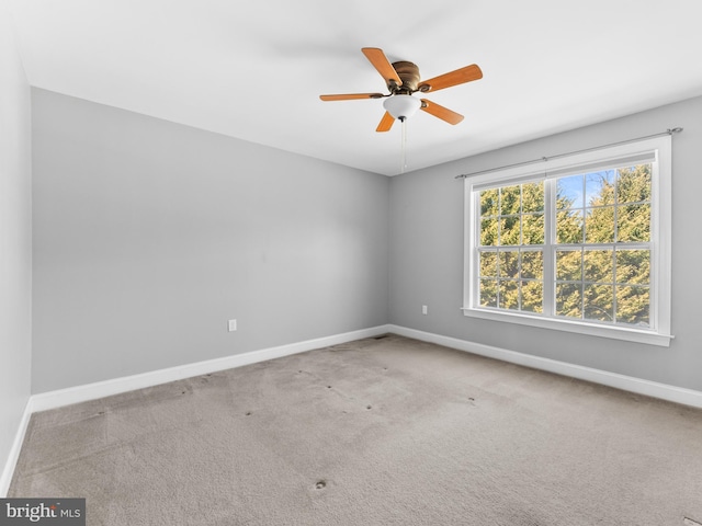 empty room with baseboards, carpet floors, and a ceiling fan