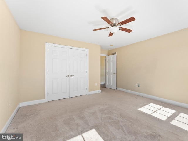 unfurnished bedroom with baseboards, a closet, carpet floors, and ceiling fan