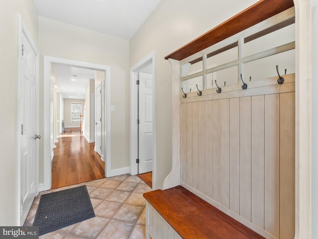 mudroom featuring light tile patterned floors and baseboards