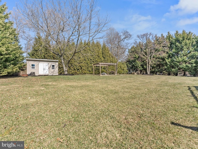 view of yard featuring a storage unit, an outbuilding, and a pergola