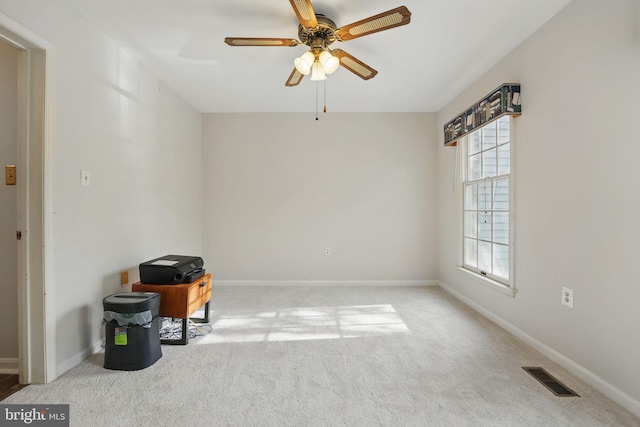 carpeted spare room featuring baseboards, ceiling fan, and visible vents