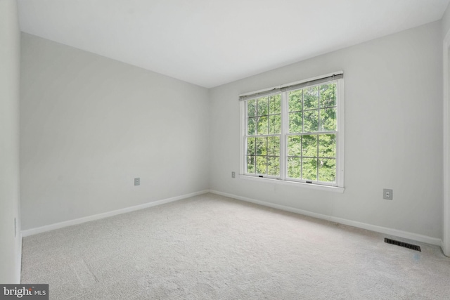 empty room featuring baseboards, carpet, and visible vents