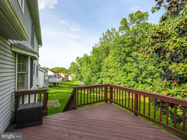 wooden deck featuring a lawn